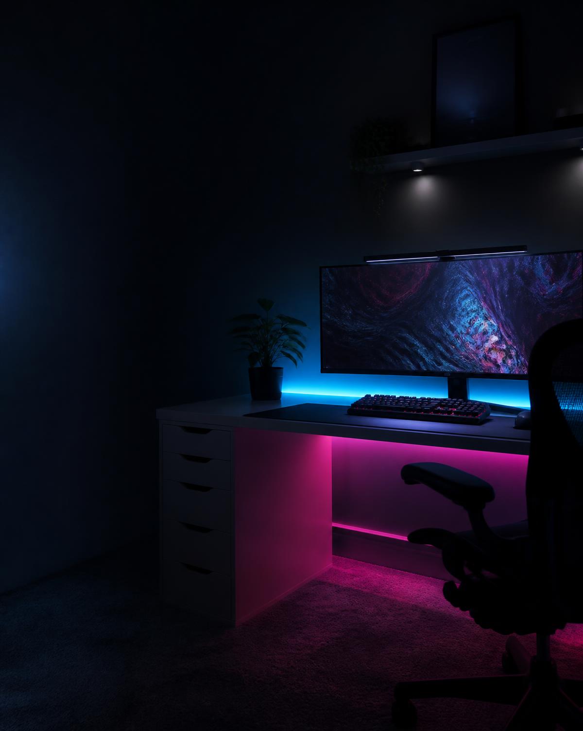 Teen bedroom desk at night with cyan and magenta LED strip glow behind an ultrawide monitor