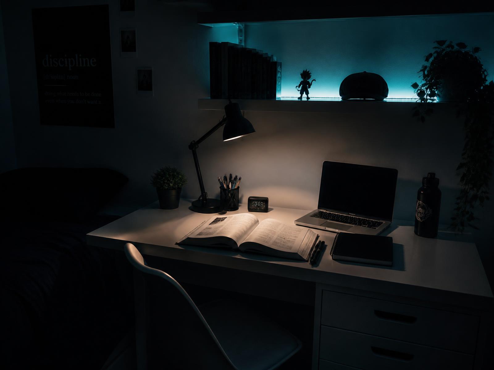 Dark teen bedroom with a white study desk, lamp, open textbook and cyan shelf lighting